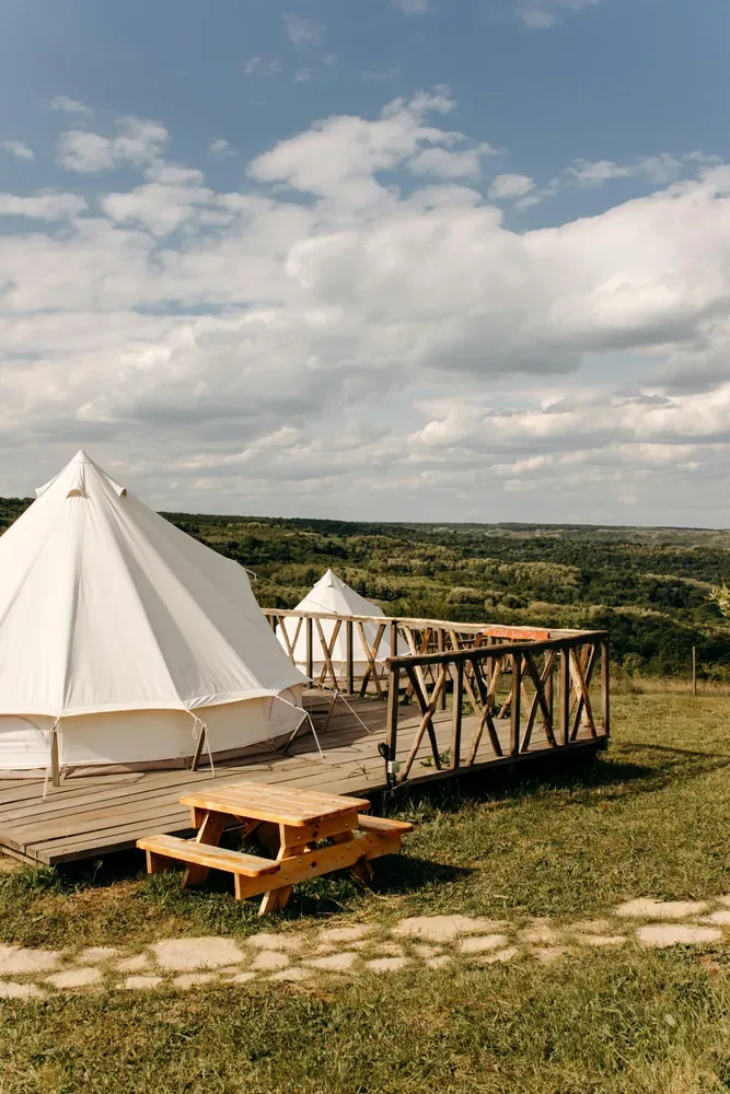 Glamping tents on a wooden deck overlooking a valley
